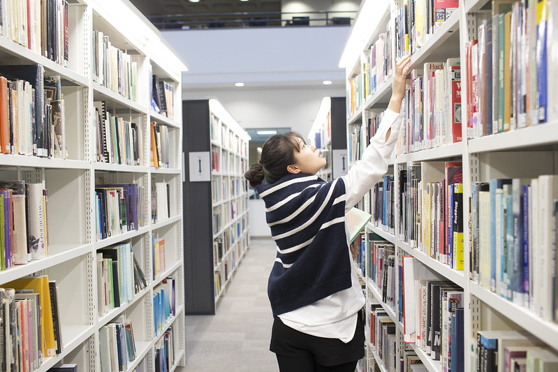 Student looking at books in library
