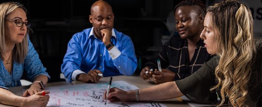 White and black students sitting at a work table writing