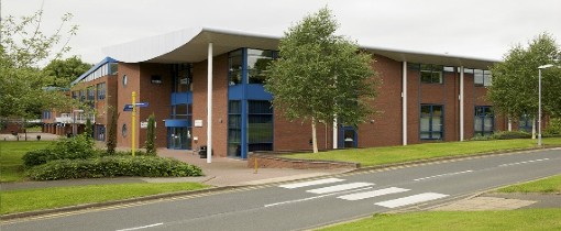 Exterior of Telford Campus, a building surrounded by green areas and past a crossing