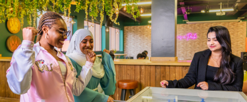 Three students sitting at a table in a restaurant