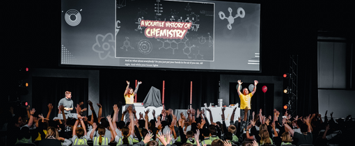 Picture of a crowd with their hands in the air.