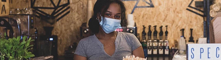 Staff member at Ra coffee wearing a mask