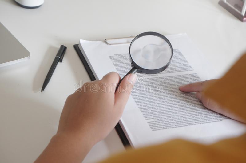 A magnifying glass held to a document