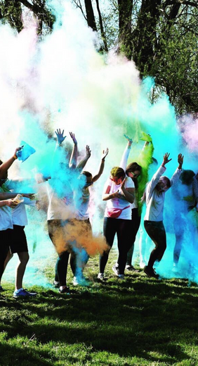 Image of a colour run event with runners surrounded by multicoloured smoke