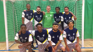 Male students in sports uniforms, standing in front of a goal