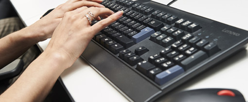 Photo of a female student using a keyboard and mouse