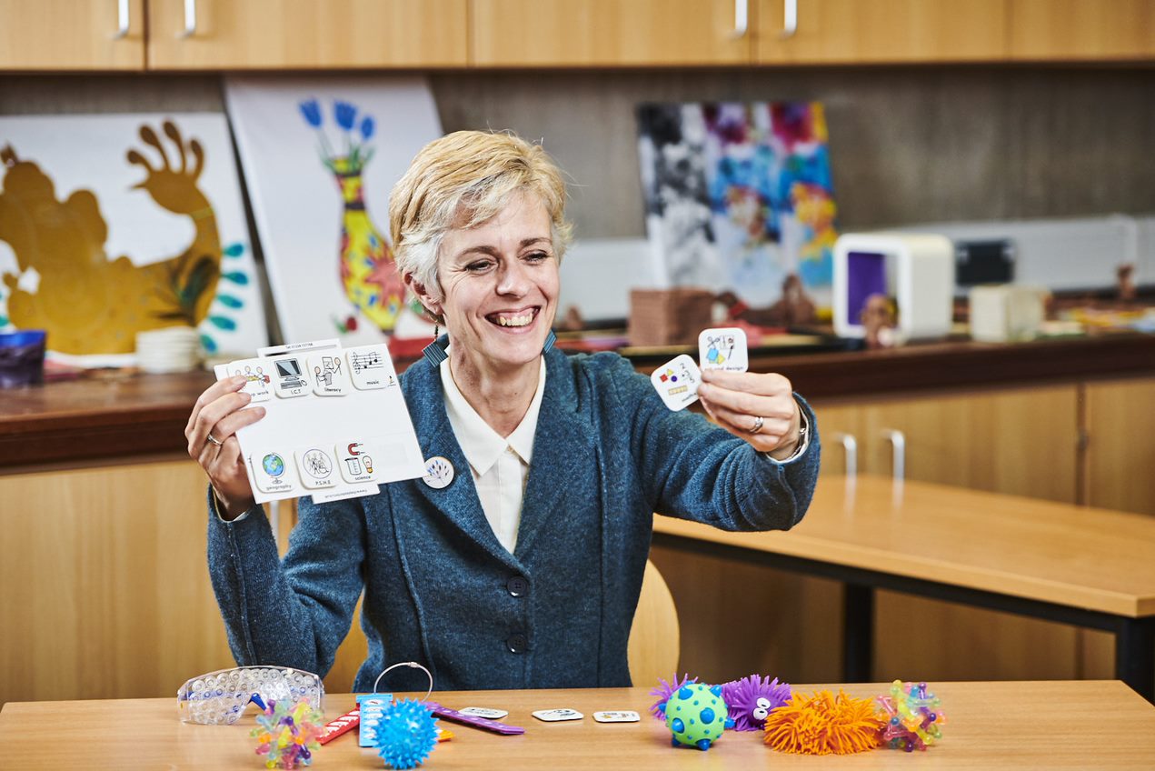 A woman at a table with items used for teaching young children